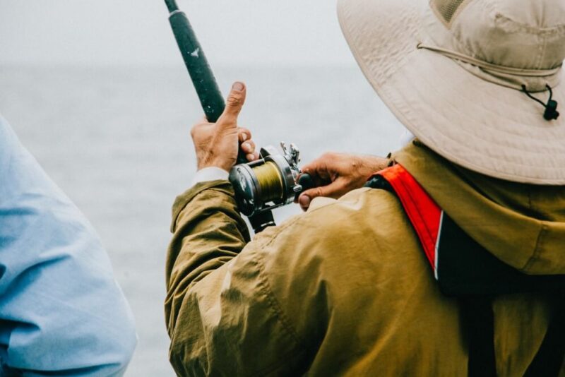 homem pescando em um barco com a melhor carretilha de pesca em mãos