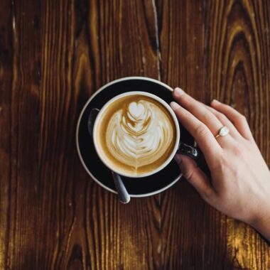 Mãos segurando xícara com café