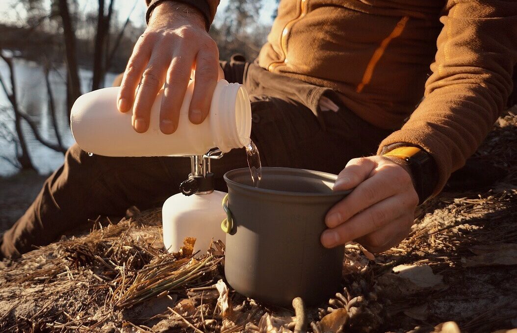 homem utilizando um kit de cozinha para camping