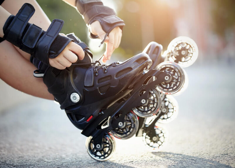 Pessoas colocando um patins inline nos pés.