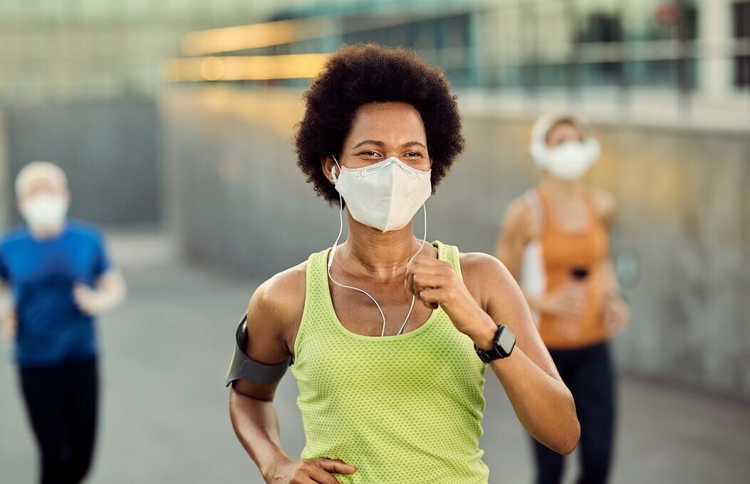 corredores correndo com máscara de proteção