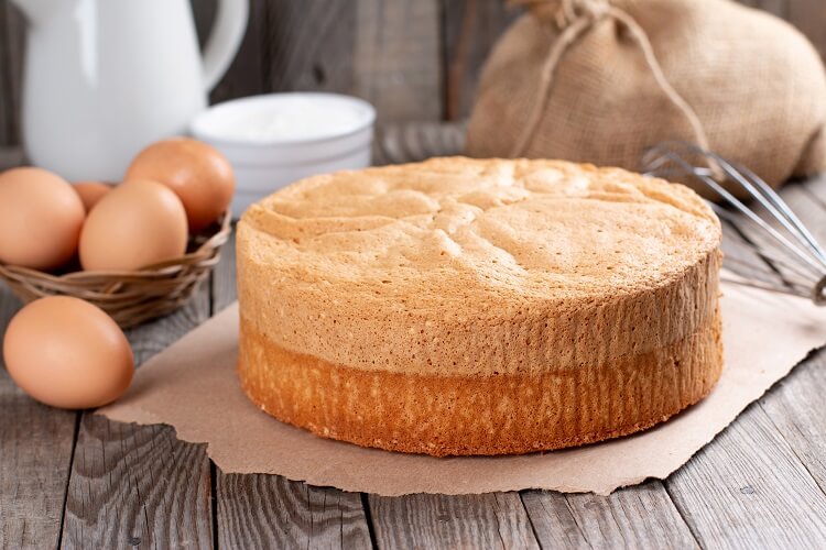 Pão de ló com ingredientes ao fundo.