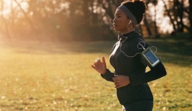 mulher correndo em um parque vestindo roupas de corrida feminina, com fone e braçadeira para celular