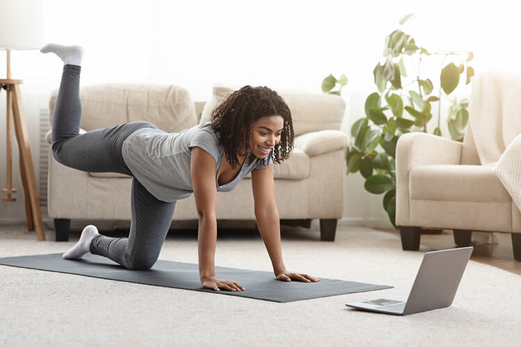 mulher fazendo aula de yoga em casa