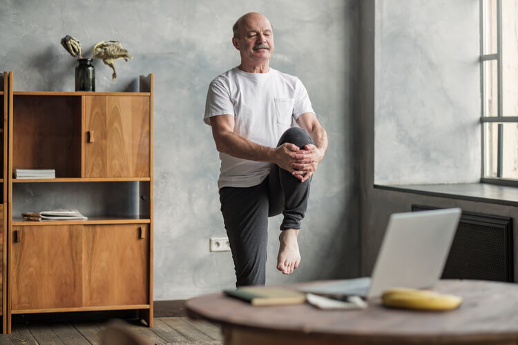 homem fazendo aula de yoga em casa